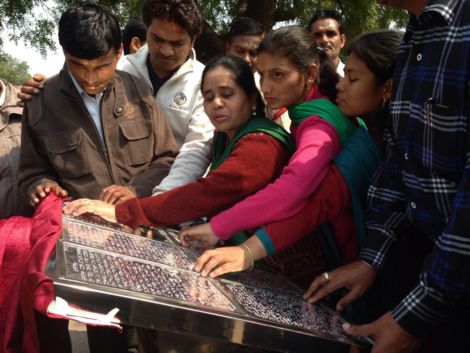 Visually impaired visitors reading the braille information board at Taj Mahal